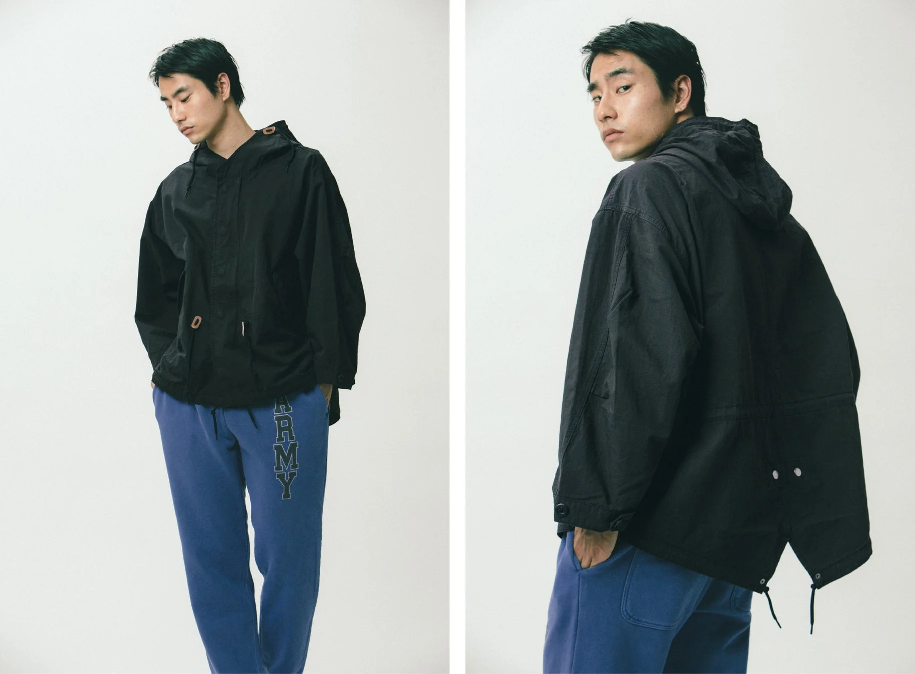 黒いフード付きジャケットと青いスウェットパンツの男性モデル