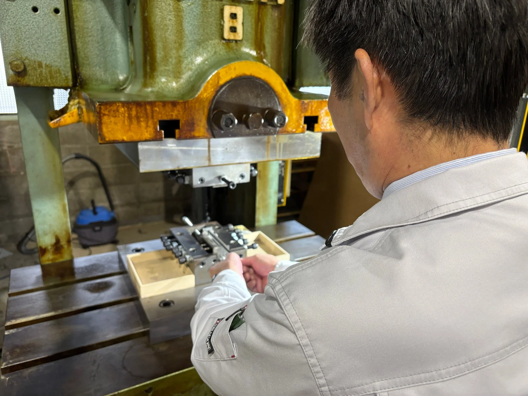 工場内で大型の産業機械を操作する男性