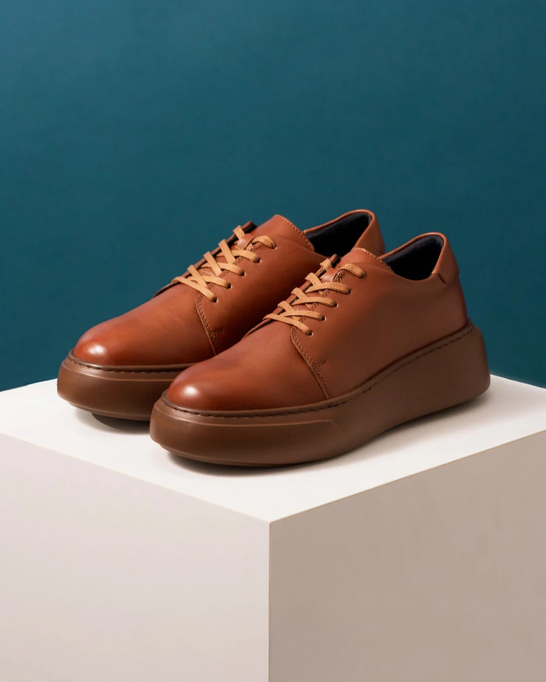 白い台の上の茶色い革靴