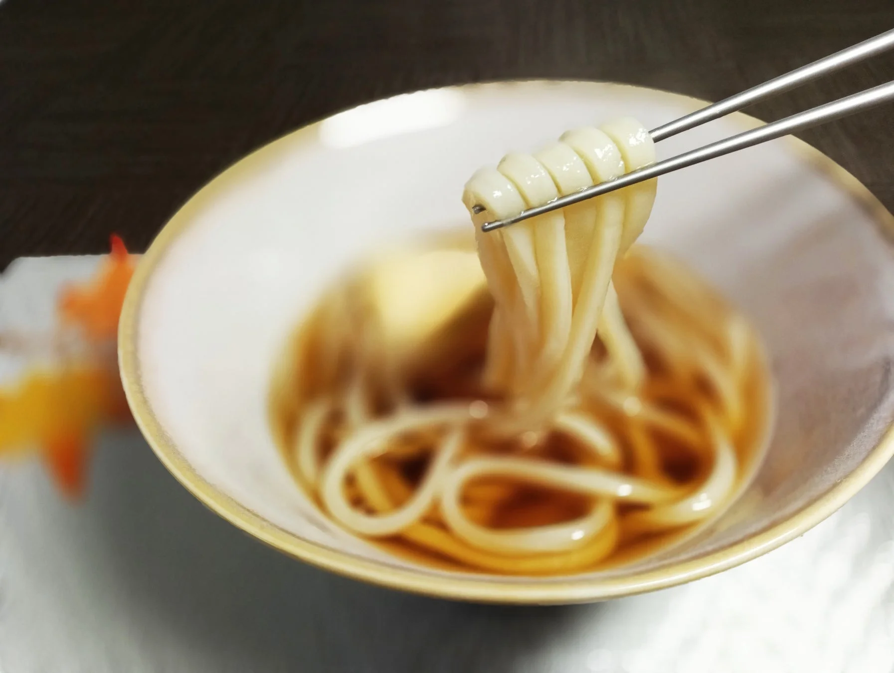 箸で持ち上げられた温かいうどん