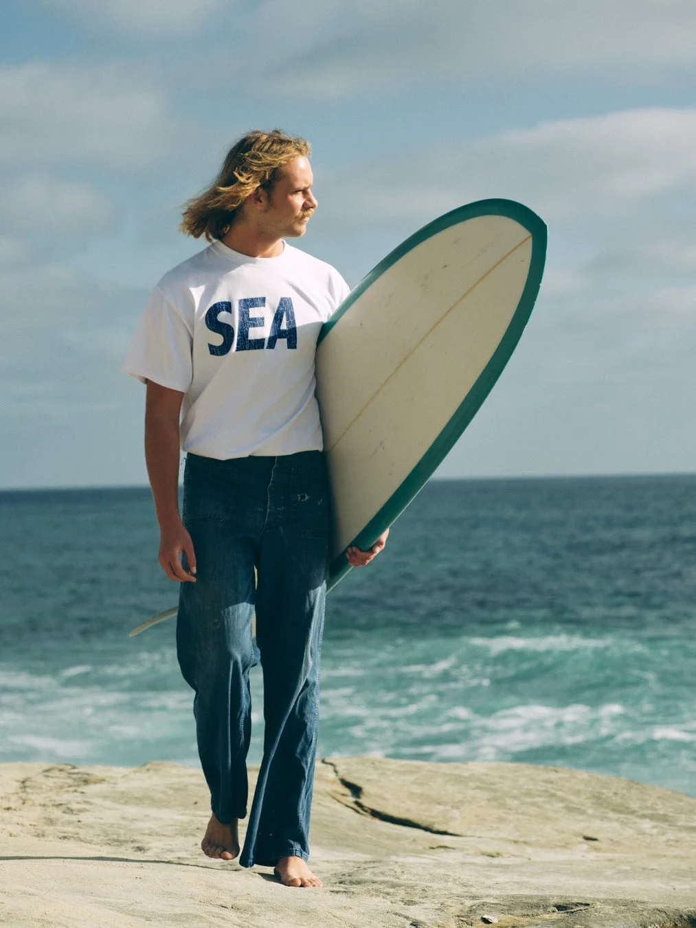 サーフボードを抱える男性のイメージ