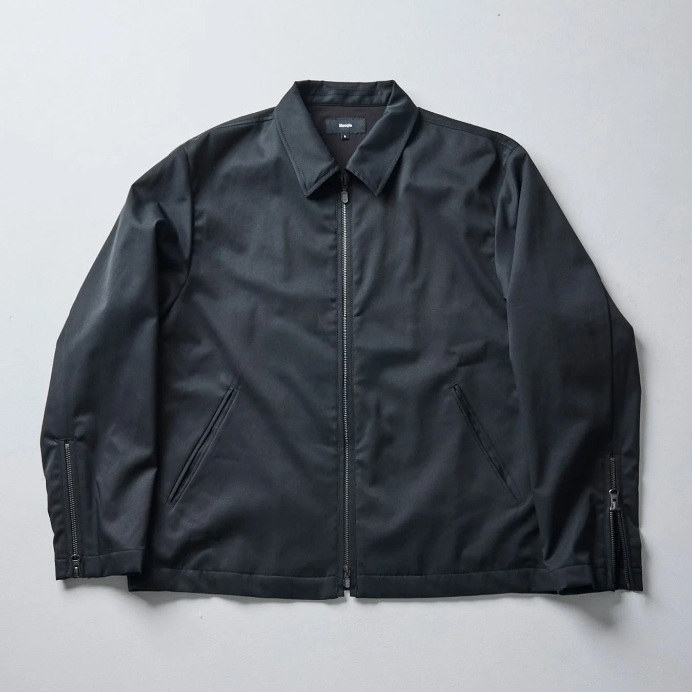 襟付きでジッパー開閉式の黒いジャケット