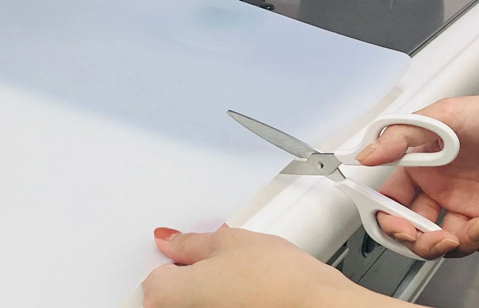 ハサミでシートをカットする手元