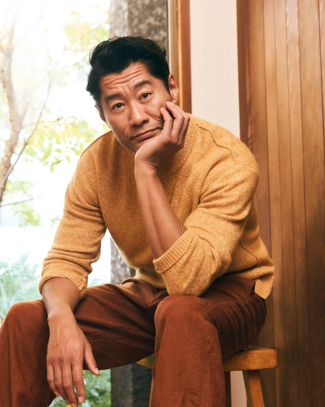 黄土色のセーターと茶色のパンツを着用した男性