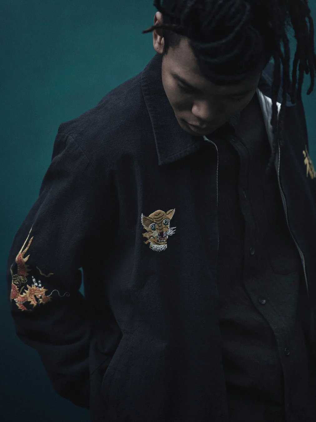 虎と龍の刺繍が入ったジャケットを着用した男性モデル