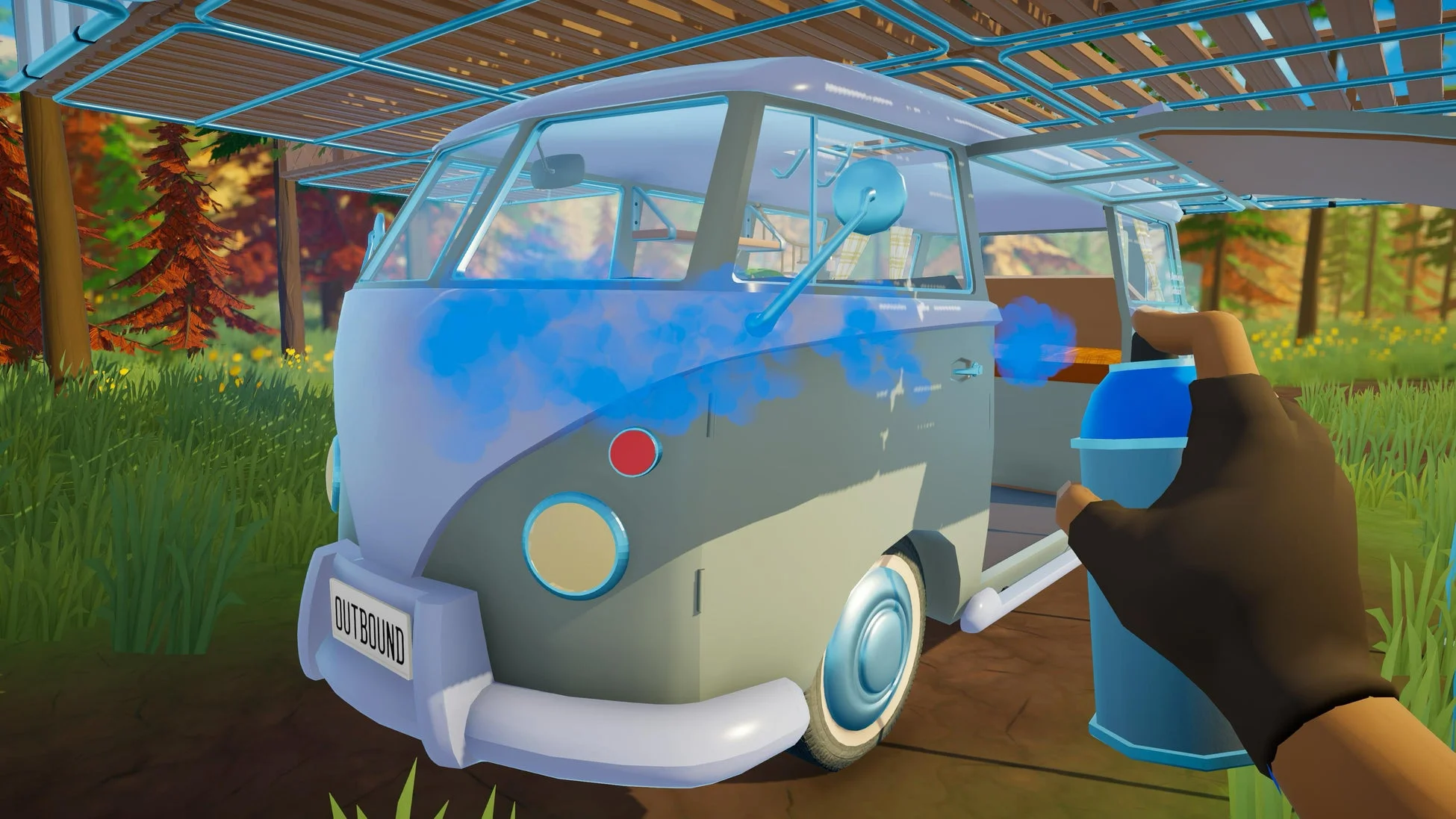 手袋をはめた手が、青いスプレー缶でライトグレーのバンに青い塗料を吹き付けている様子。背景には緑の草や赤い木々が見え、木製の屋根の下で車をカスタマイズしているようだ。