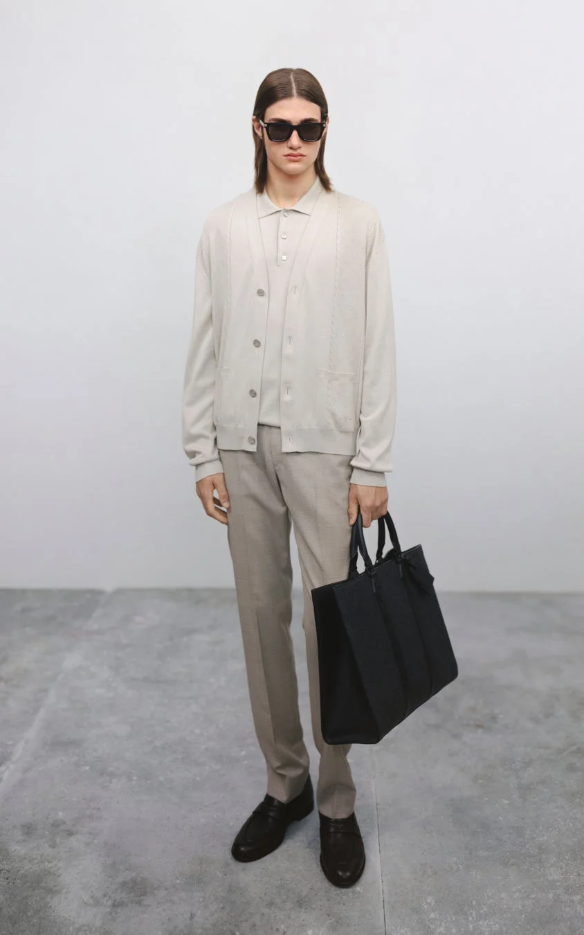 カーディガンとポロシャツ、スラックスを着用した男性