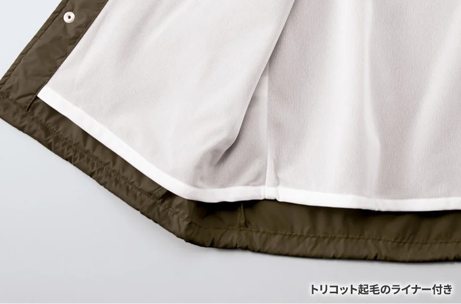 カーキ色のアウターの内側が写っており、白いトリコット起毛のライナーが付属している様子がわかる。暖かみのある素材感が特徴。