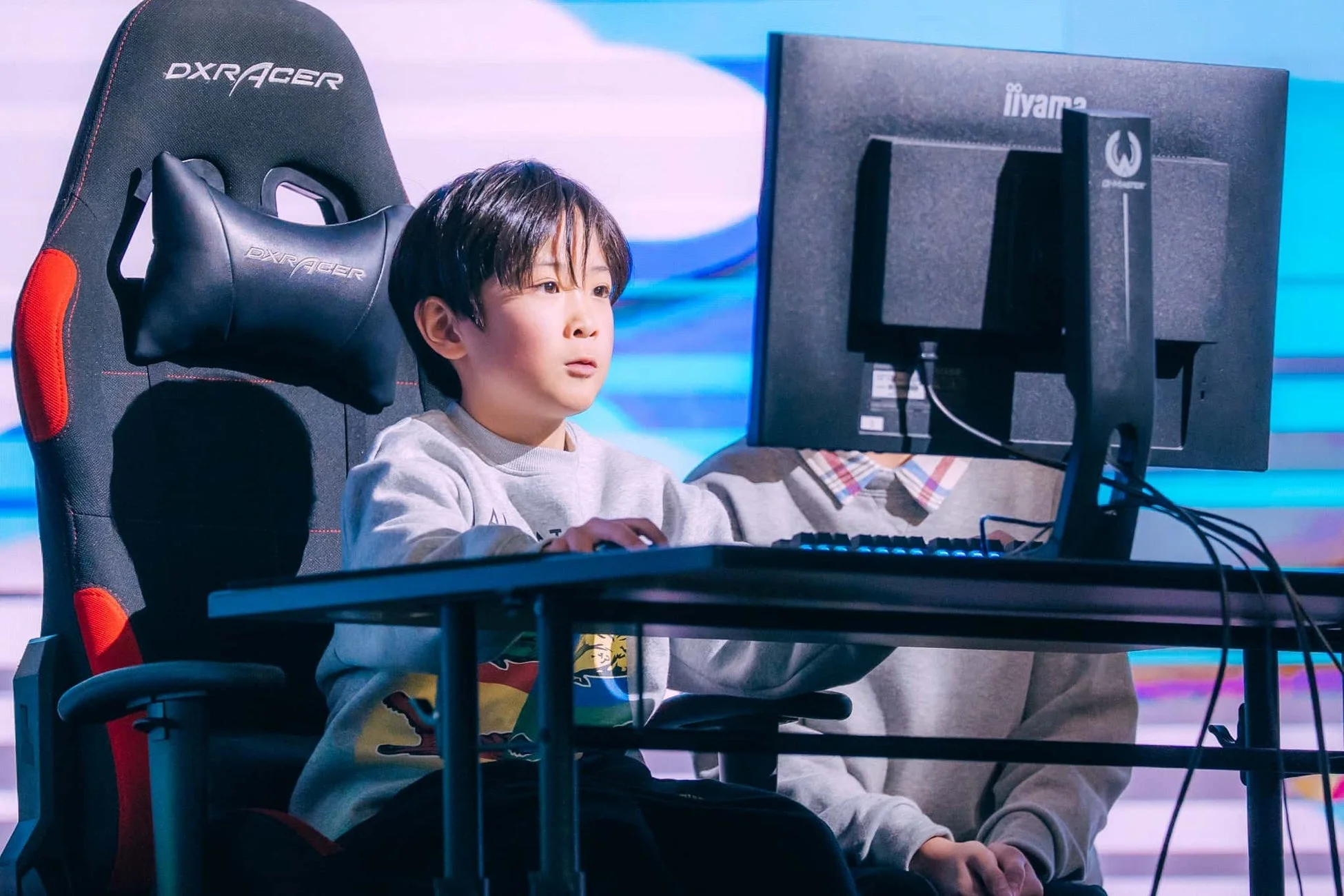 ゲーミングチェアに座ってPCゲームに集中する少年