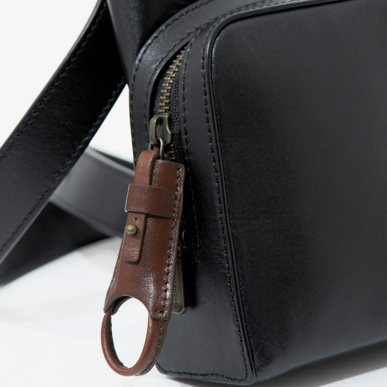 黒い革製バッグのジッパーに付けられたZipzip™