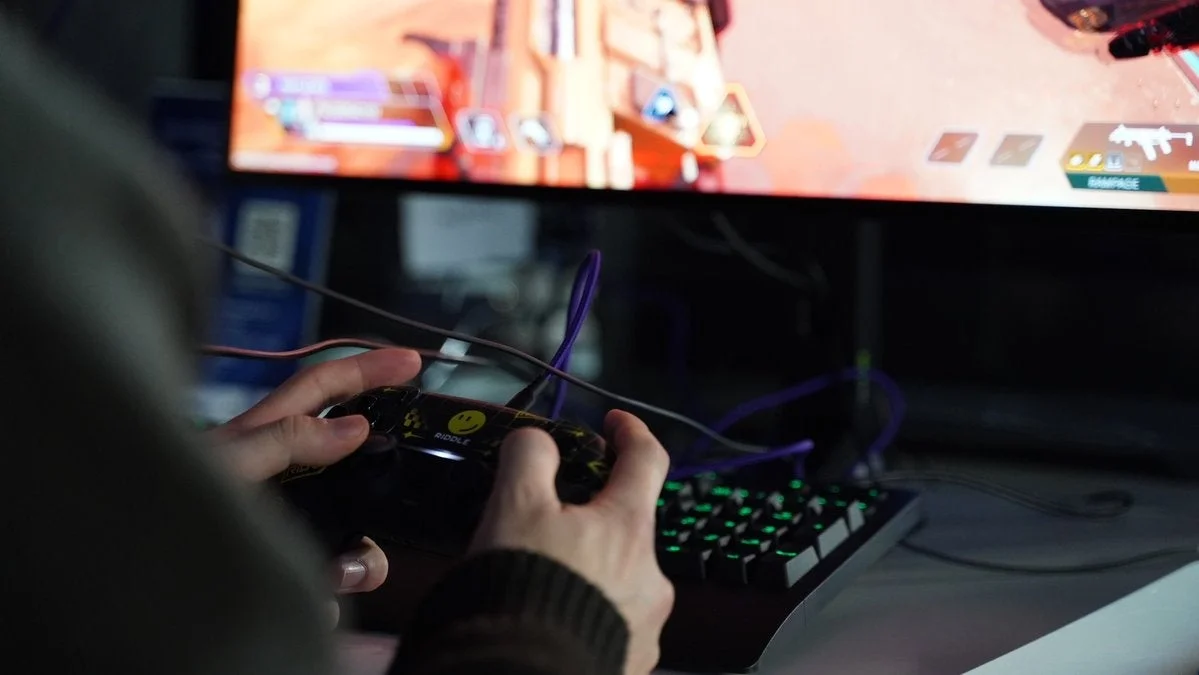 モニターの前でコントローラーを操作する人物