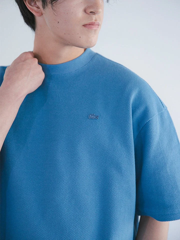 青色の鹿の子編みTシャツを着た若い男性