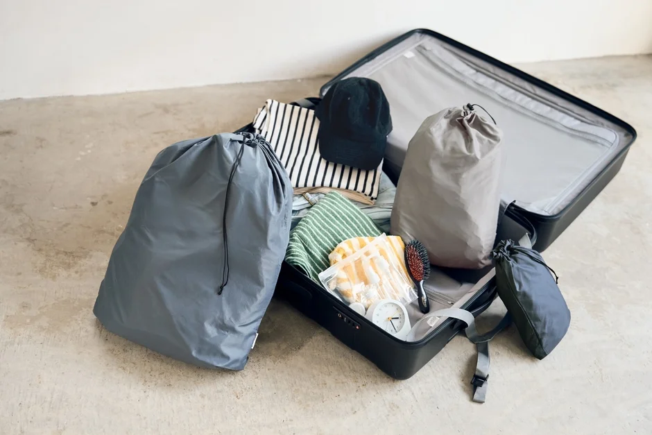 開いたスーツケースの中に、衣類や巾着袋、トラベルグッズなどが整然と詰め込まれています