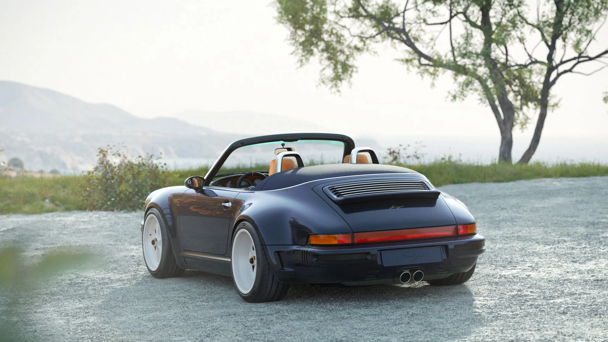 砂利道に停車した紺色のシンガー製ポルシェ911カブリオレ