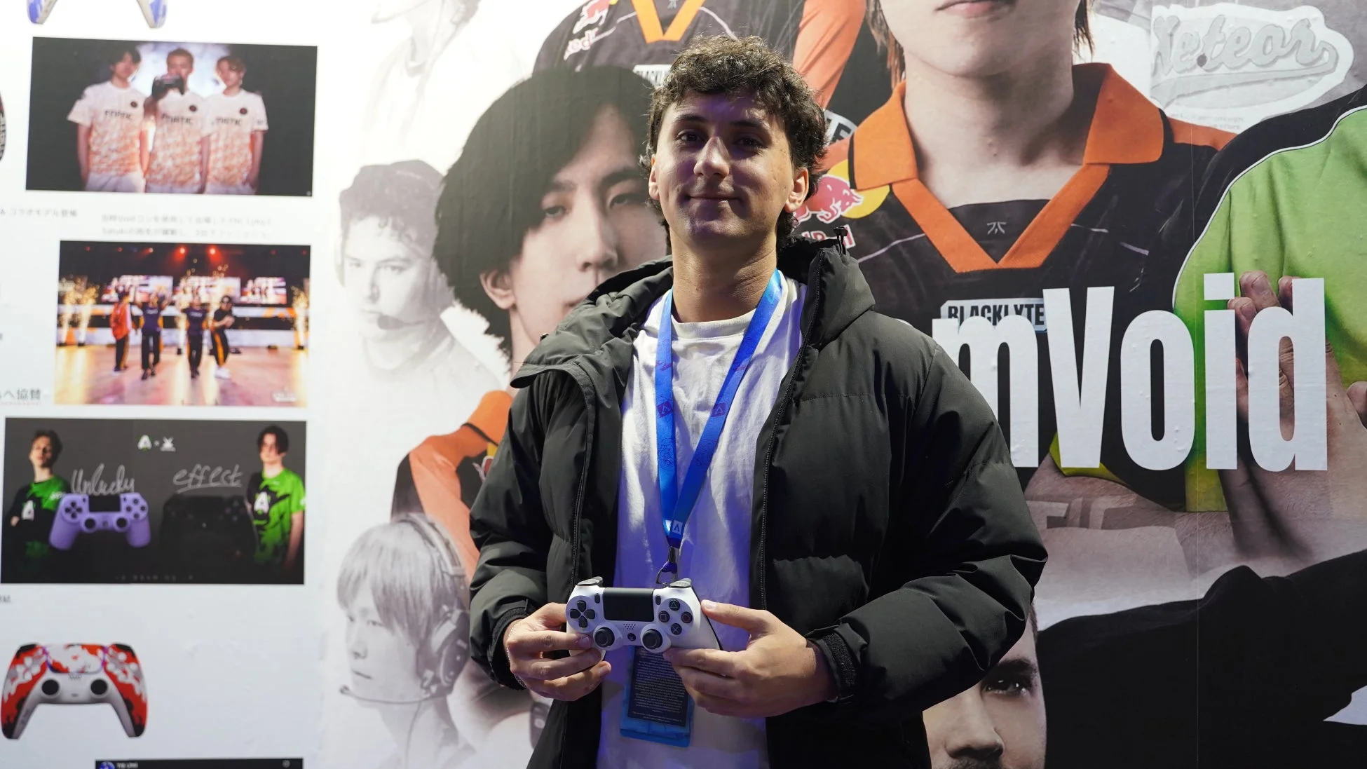 PlayStationコントローラーを持つ男性とeスポーツポスター