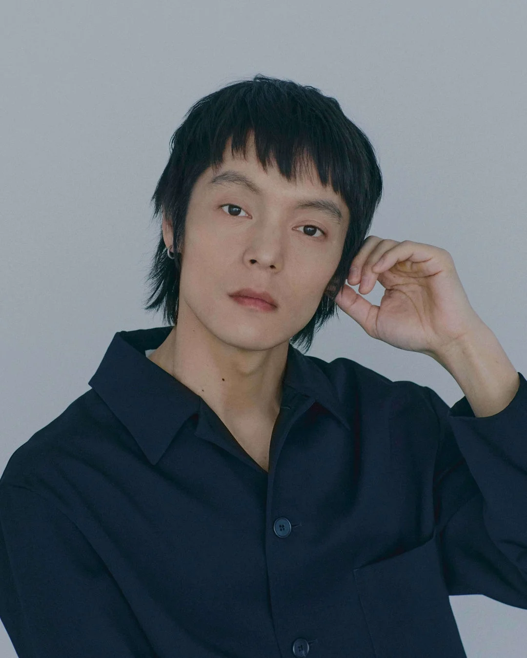 黒いシャツを着た黒髪の男性のポートレート