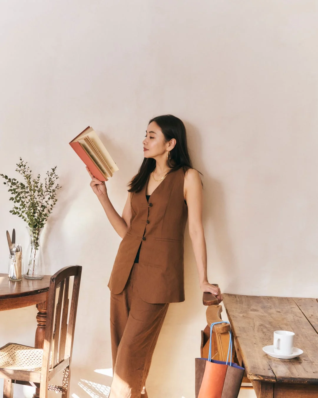 ブラウンのベストとパンツを着用した女性