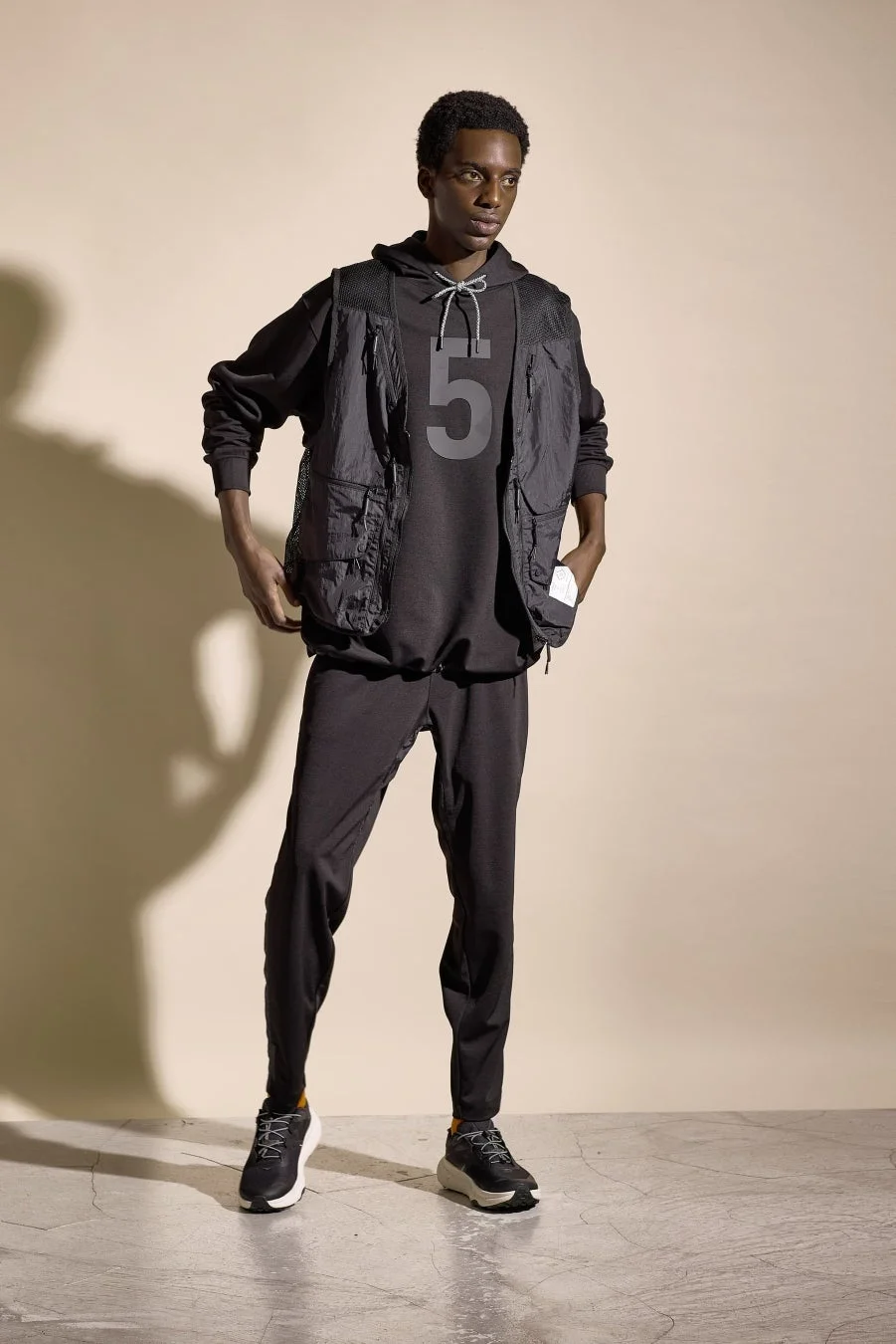 フーディーとタクティカルベストを着用した男性