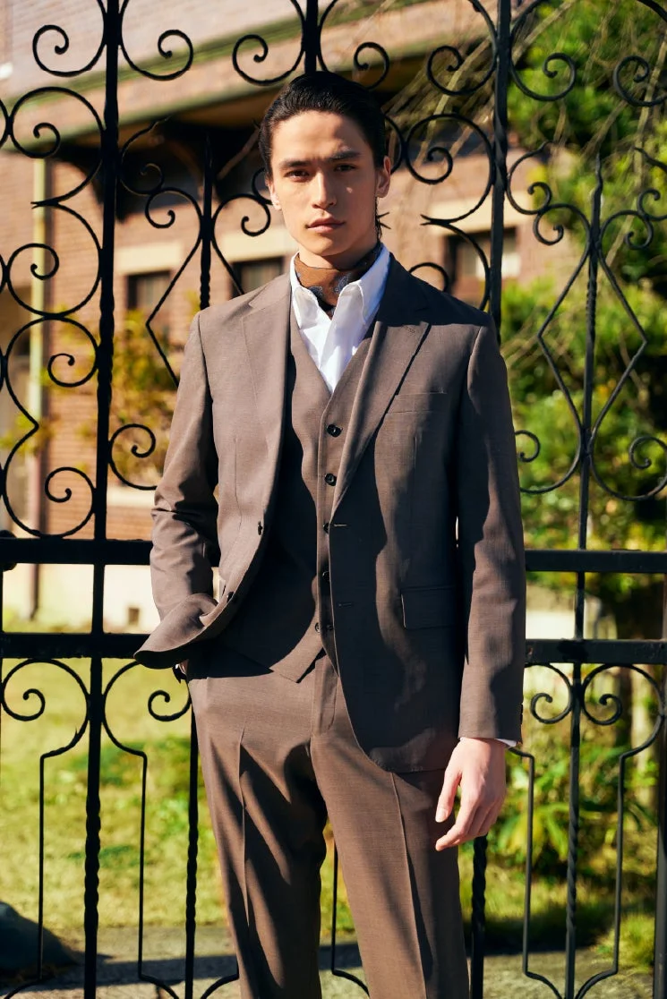 茶色のスリーピーススーツを着た男性