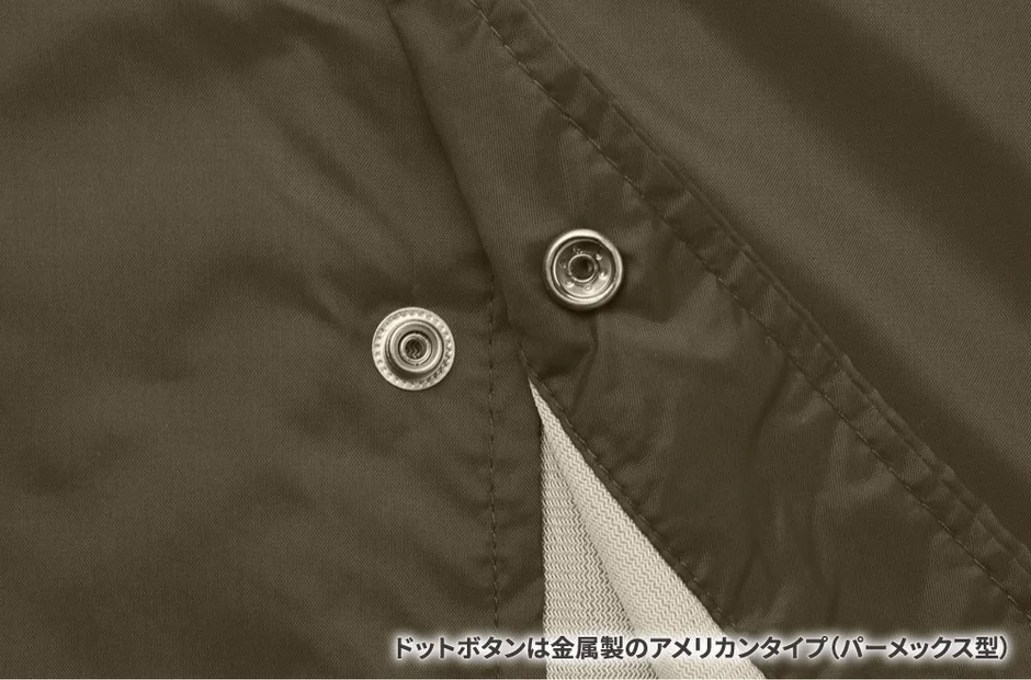 濃い茶色の生地に金属製のドットボタンが2つ配置されているクローズアップ画像です。ボタンは「アメリカンタイプ（パーメックス型）」と説明されており、生地の質感と縫い目も確認できます。