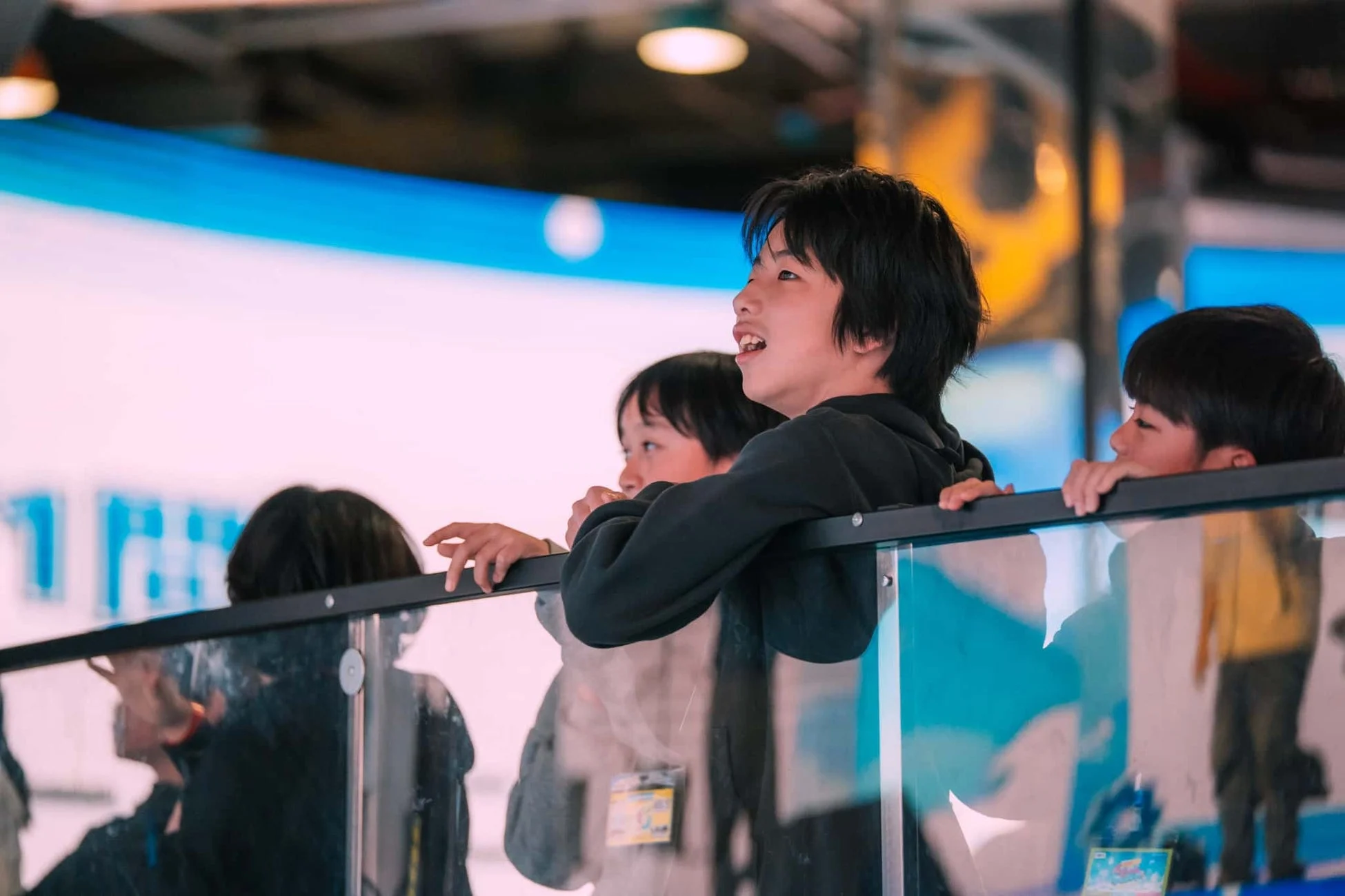 ガラス越しに何かを見上げる少年たち