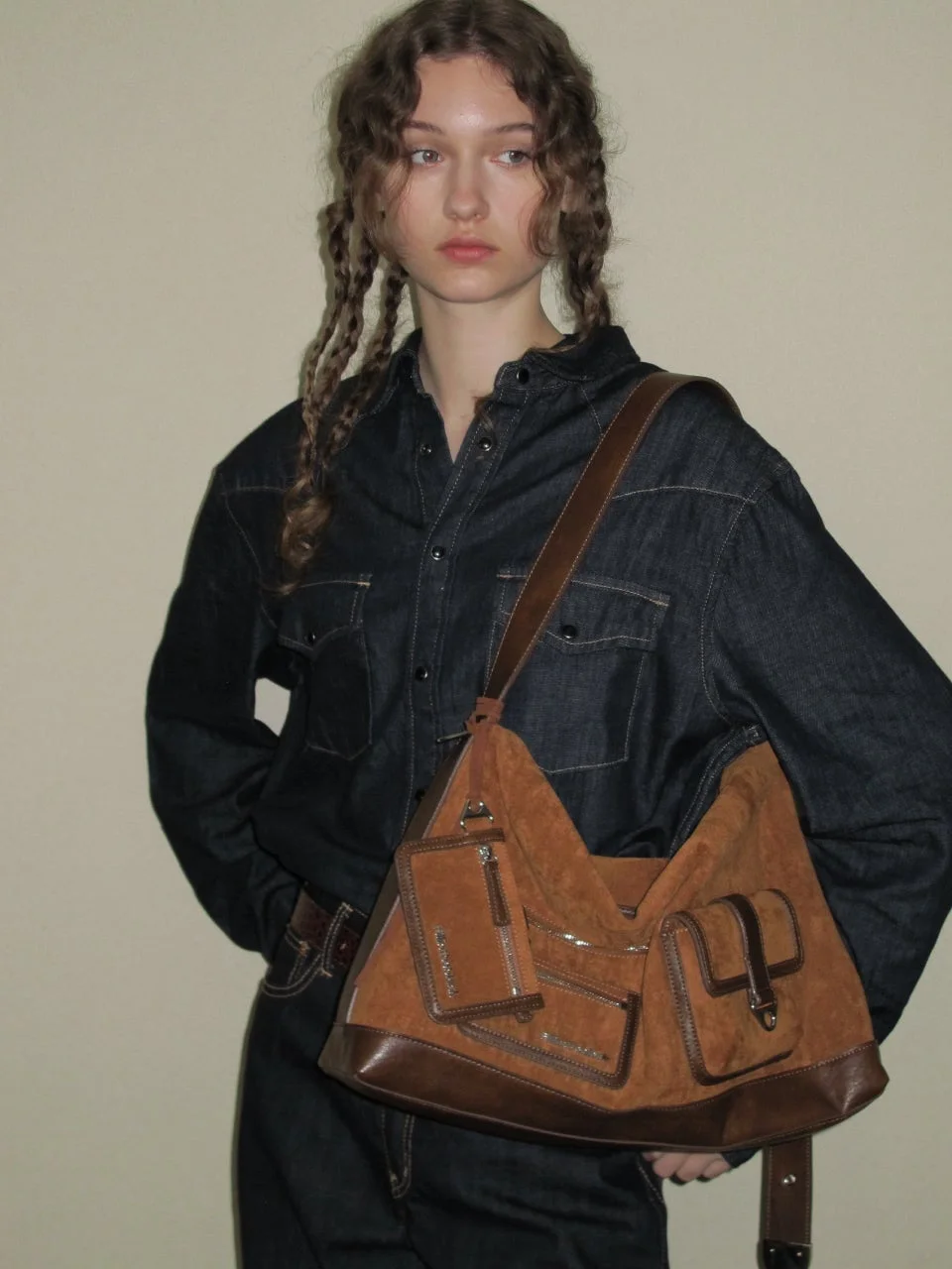 デニムシャツを着た女性とスエードバッグ