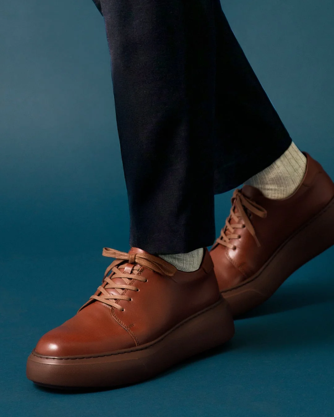 青い背景のアースブラウンの革靴