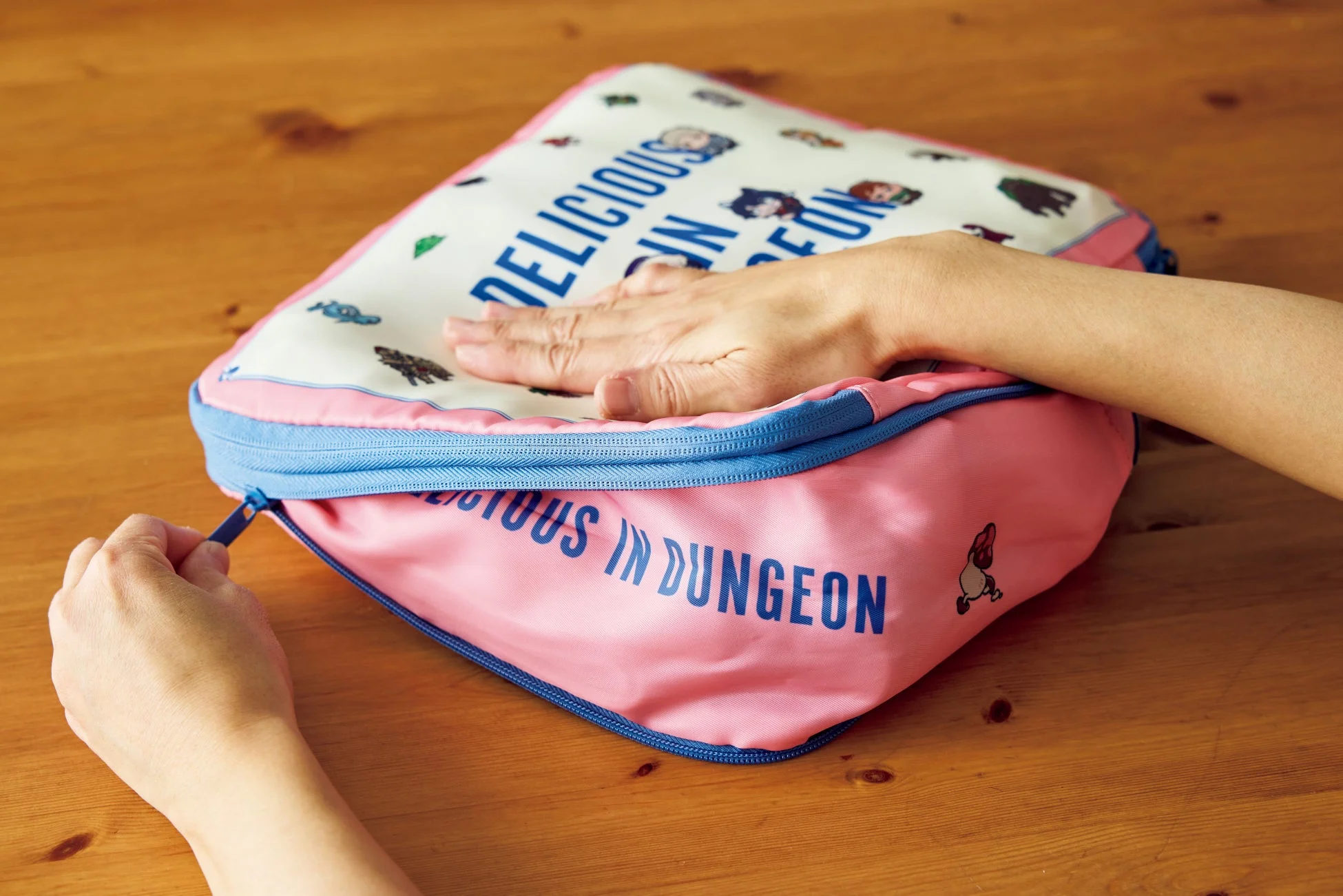 ダンジョン飯の圧縮収納ポーチのファスナーを閉める手元