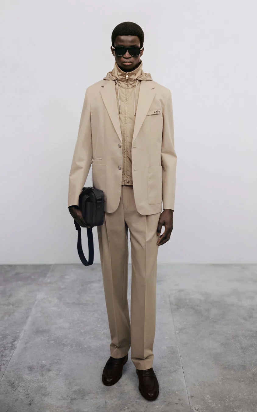 ベージュのスーツにフーディを合わせた男性