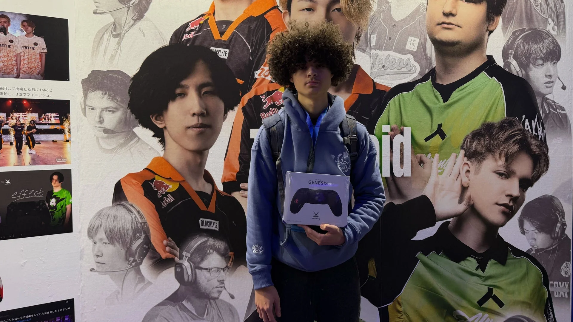 ゲームコントローラーの箱を持つ若者とeスポーツ壁画