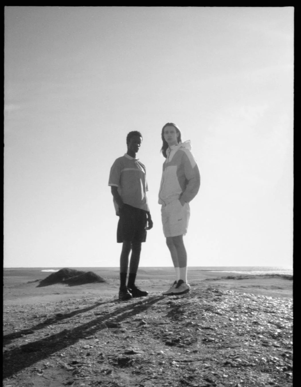 モノクロ写真で砂浜に立つ2人のモデル