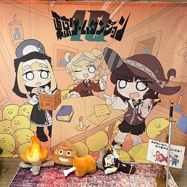 終末ゲームダンジョンⅡと書かれた背景幕に、ちびキャラのアニメキャラクター3人と多数の黄色い生物が描かれた展示風景