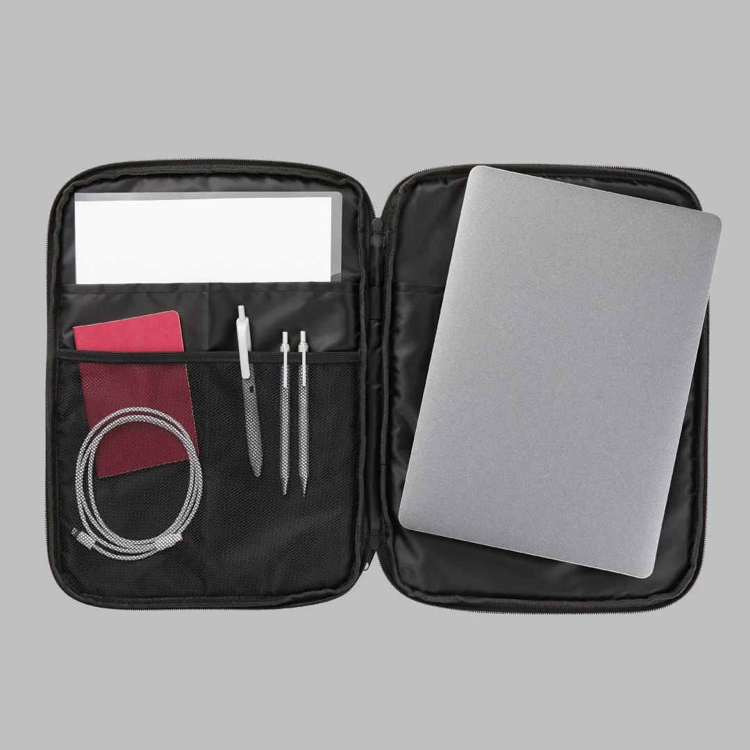 開いた黒いオーガナイザーポーチに、シルバーのノートパソコン、書類、ペン、赤いノート、充電ケーブルが整理されて収納
