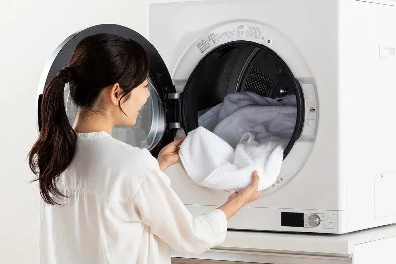 女性が洗濯物を入れている様子