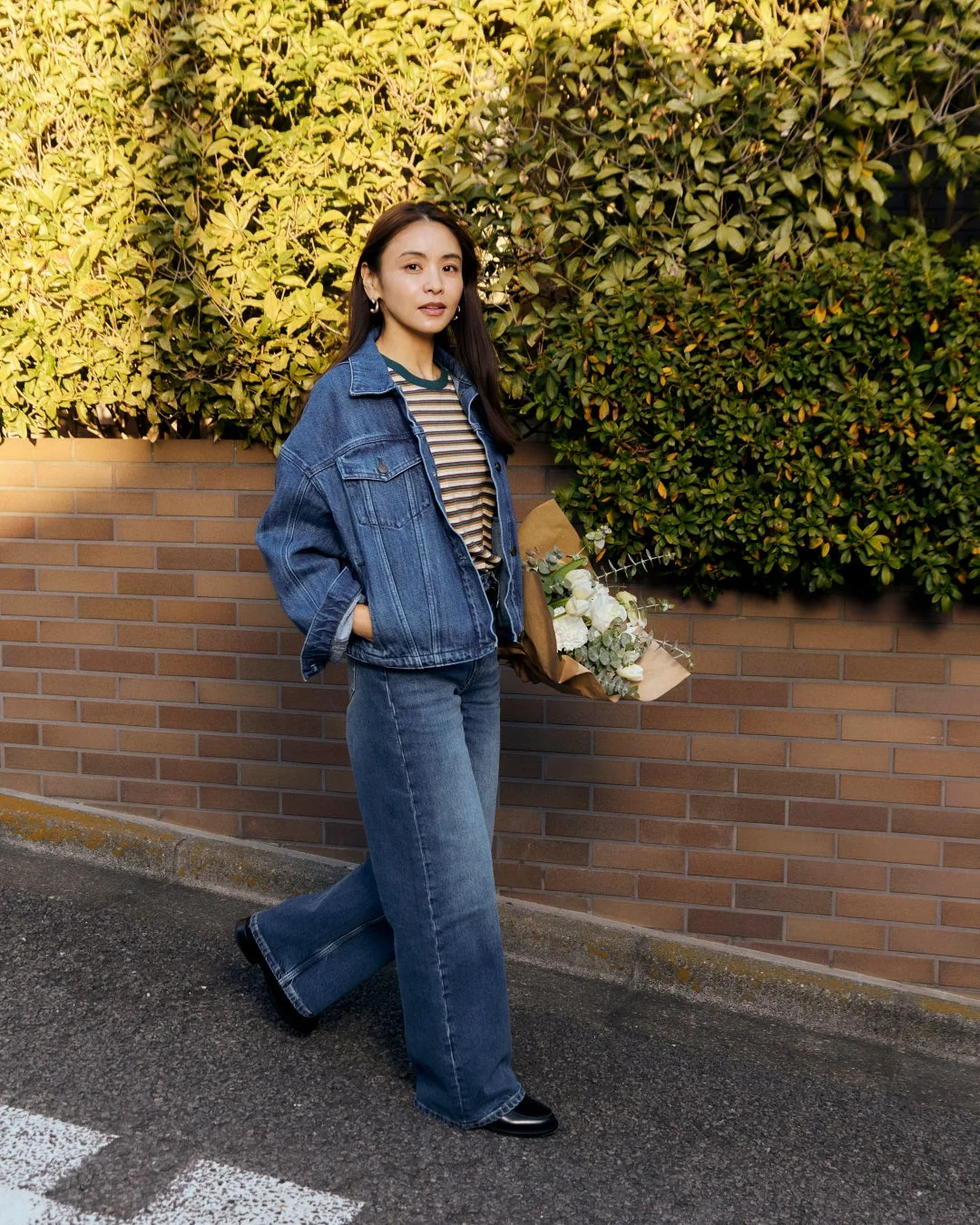 デニムジャケットとジーンズを着用した女性