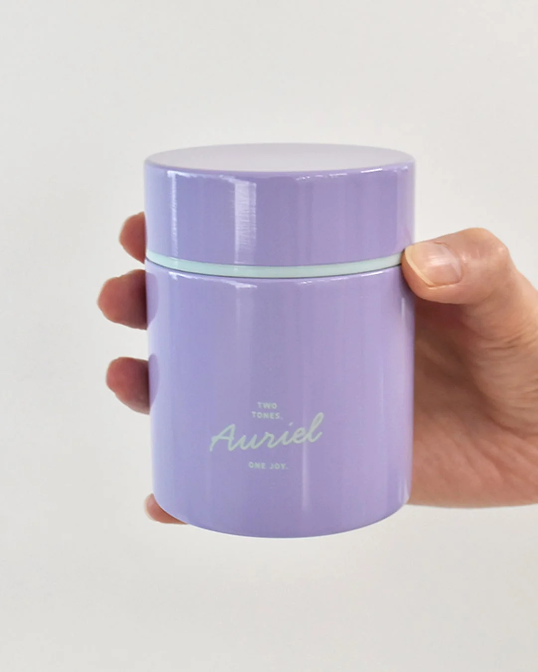 ラベンダー色の容器を持つ手
