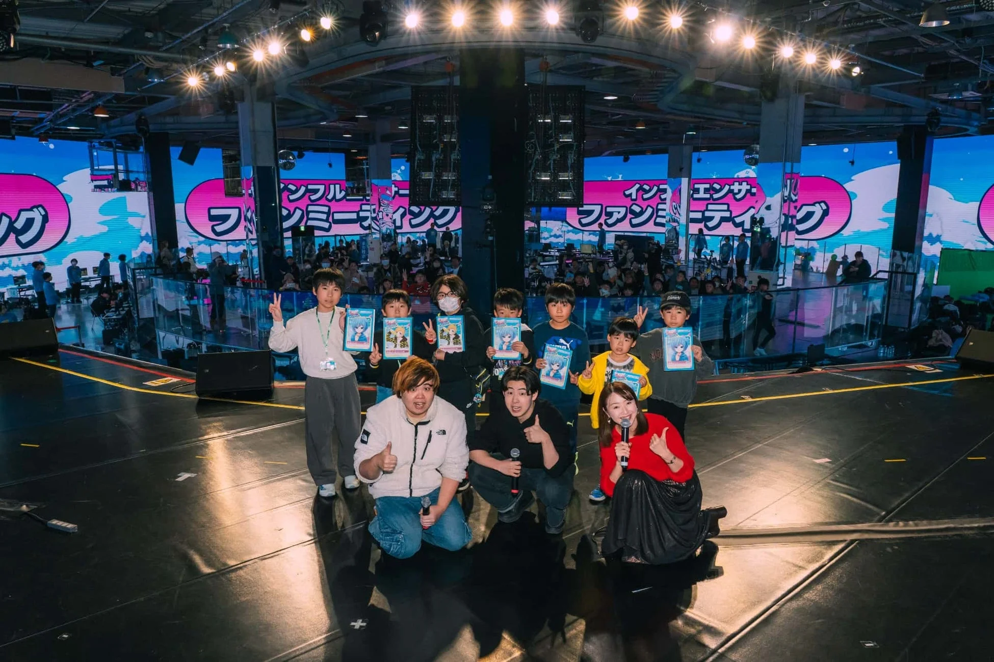ステージイベントで集合写真を撮影する子供たちと大人たち