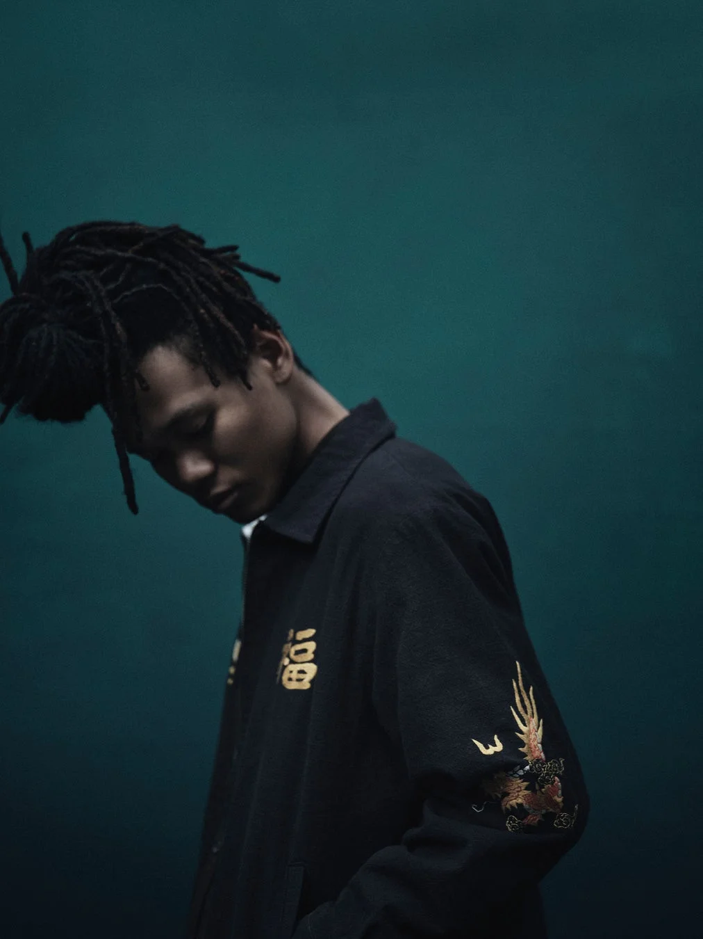 龍と「百福」の刺繍が入ったジャケットを着用した男性モデル