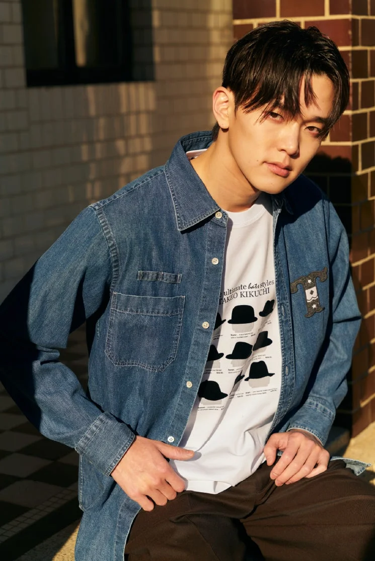 デニムシャツとハットのイラストTシャツを着た男性