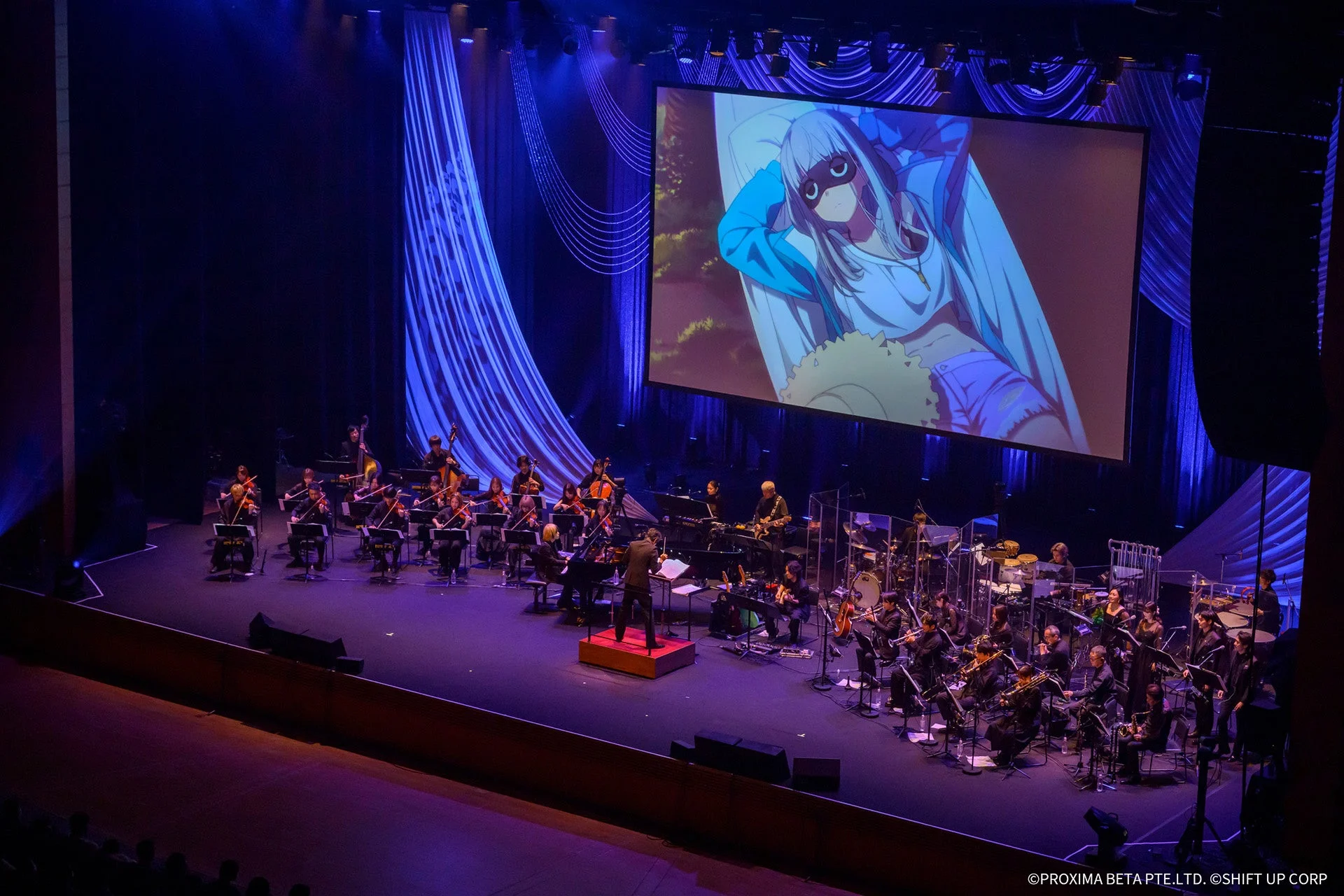ステージで演奏するオーケストラとスクリーンに映るキャラクター