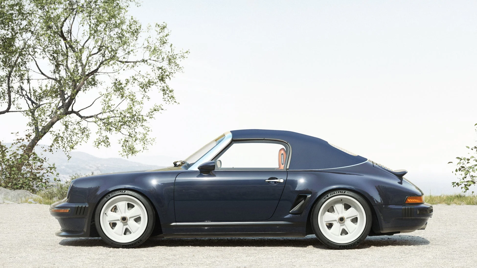 砂利道に駐車されたパシフィックブルーのカスタムポルシェ911カブリオレのサイドビュー