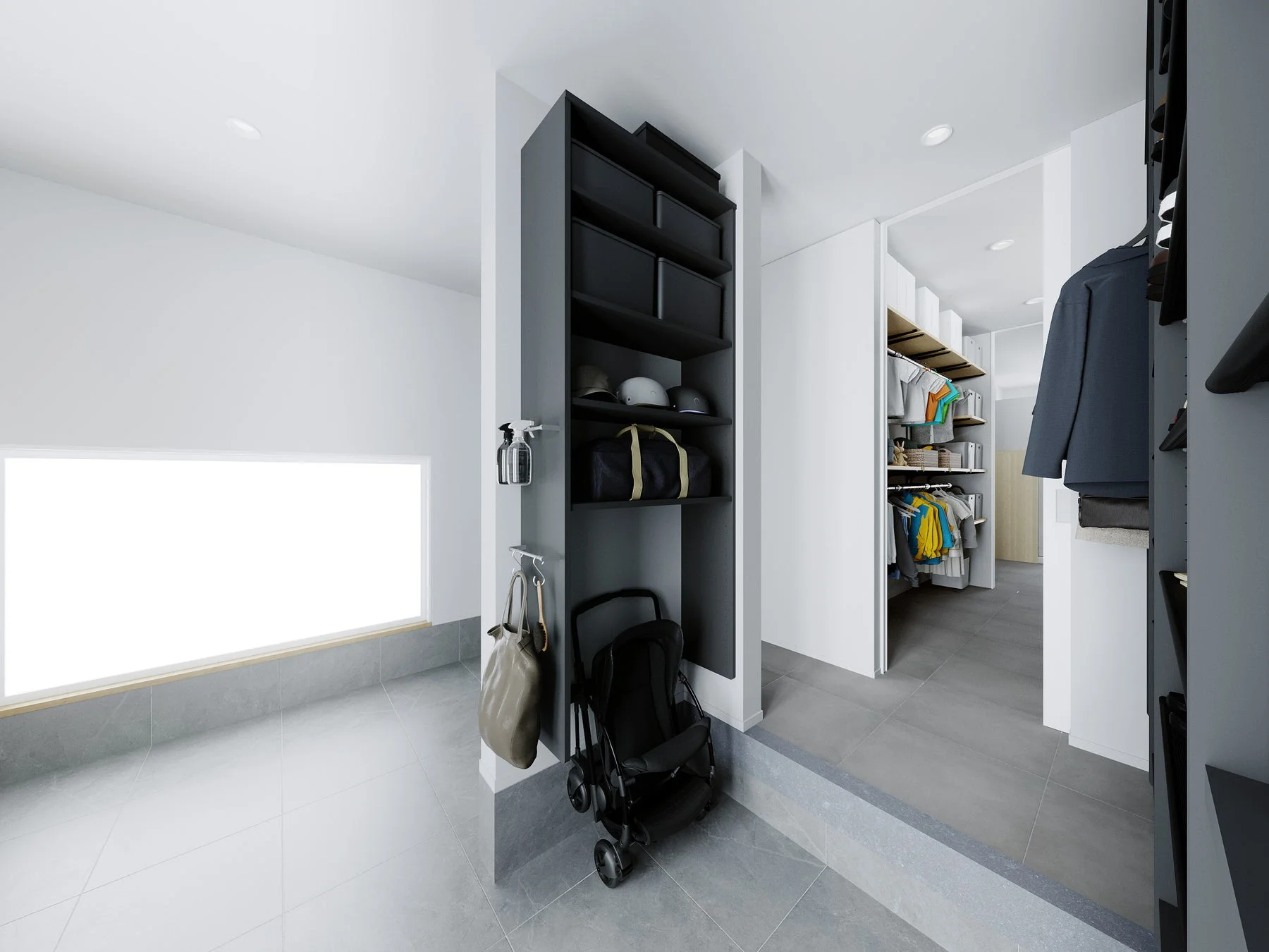 モダンな内装の玄関または土間収納スペース。壁面には黒い収納棚があり、帽子やバッグ、ベビーカーが置かれています。