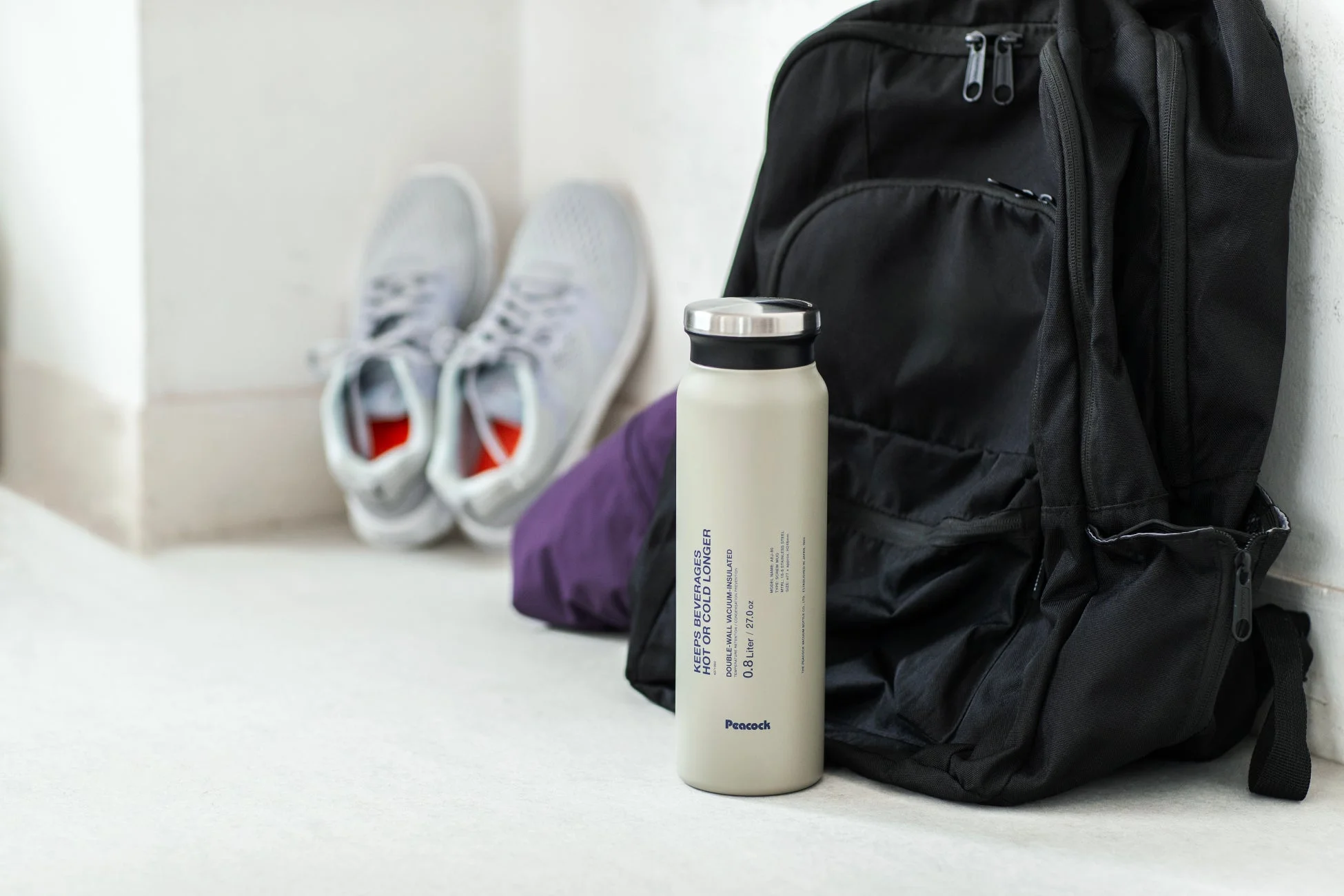 リュックサックの横に置かれたスクリューマグ