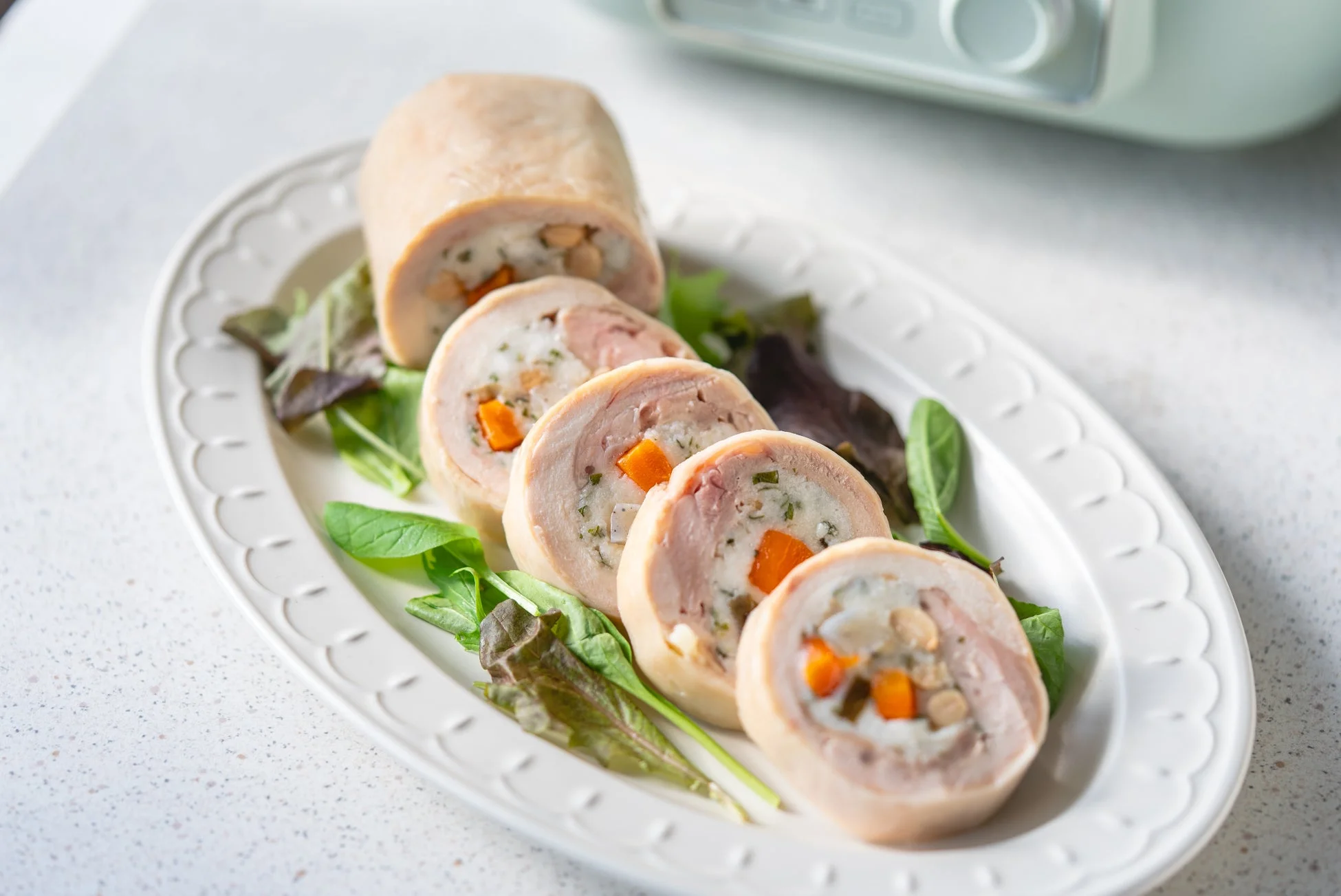 白い皿に盛り付けられた鶏肉のロールチキン