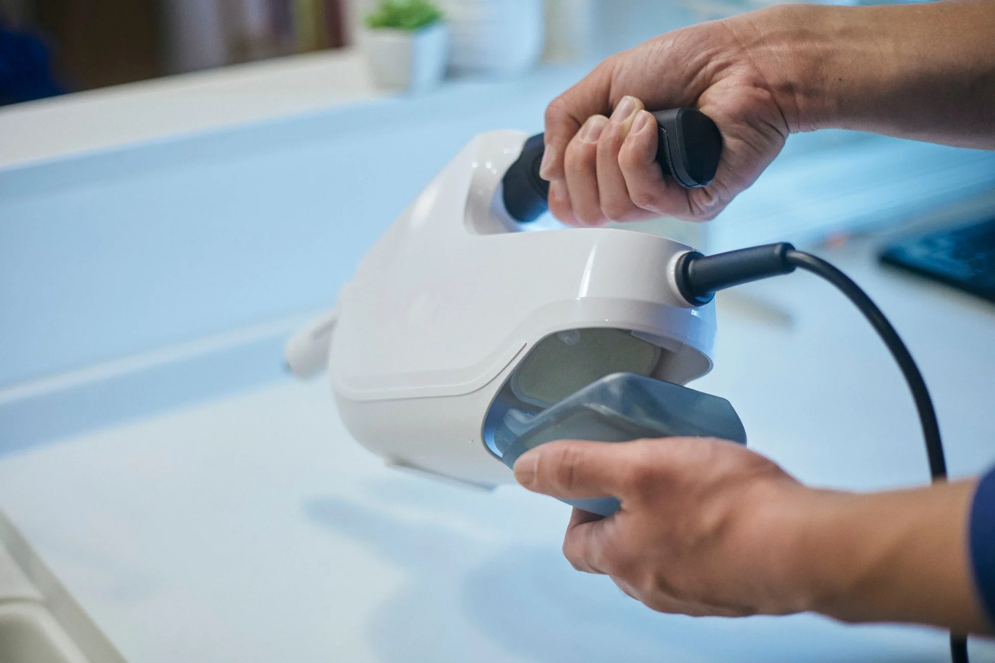 白いハンディデバイスを操作する人の手のクローズアップ