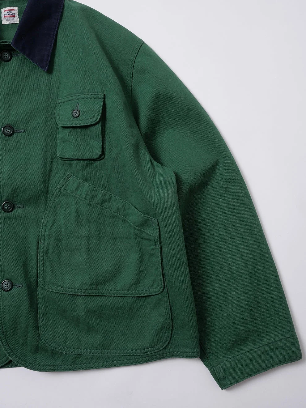 紺色の襟と複数のボタンが付いた深緑色のジャケットのクローズアップ