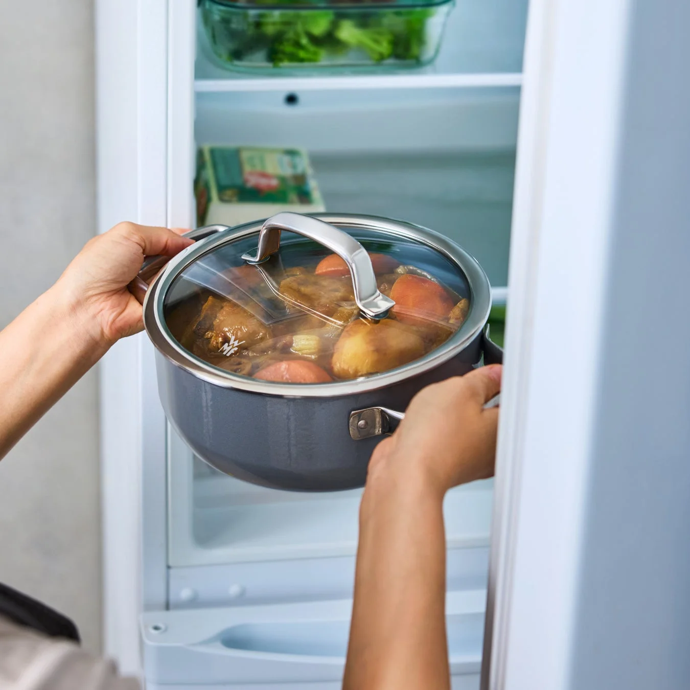 冷蔵庫に鍋をしまう様子