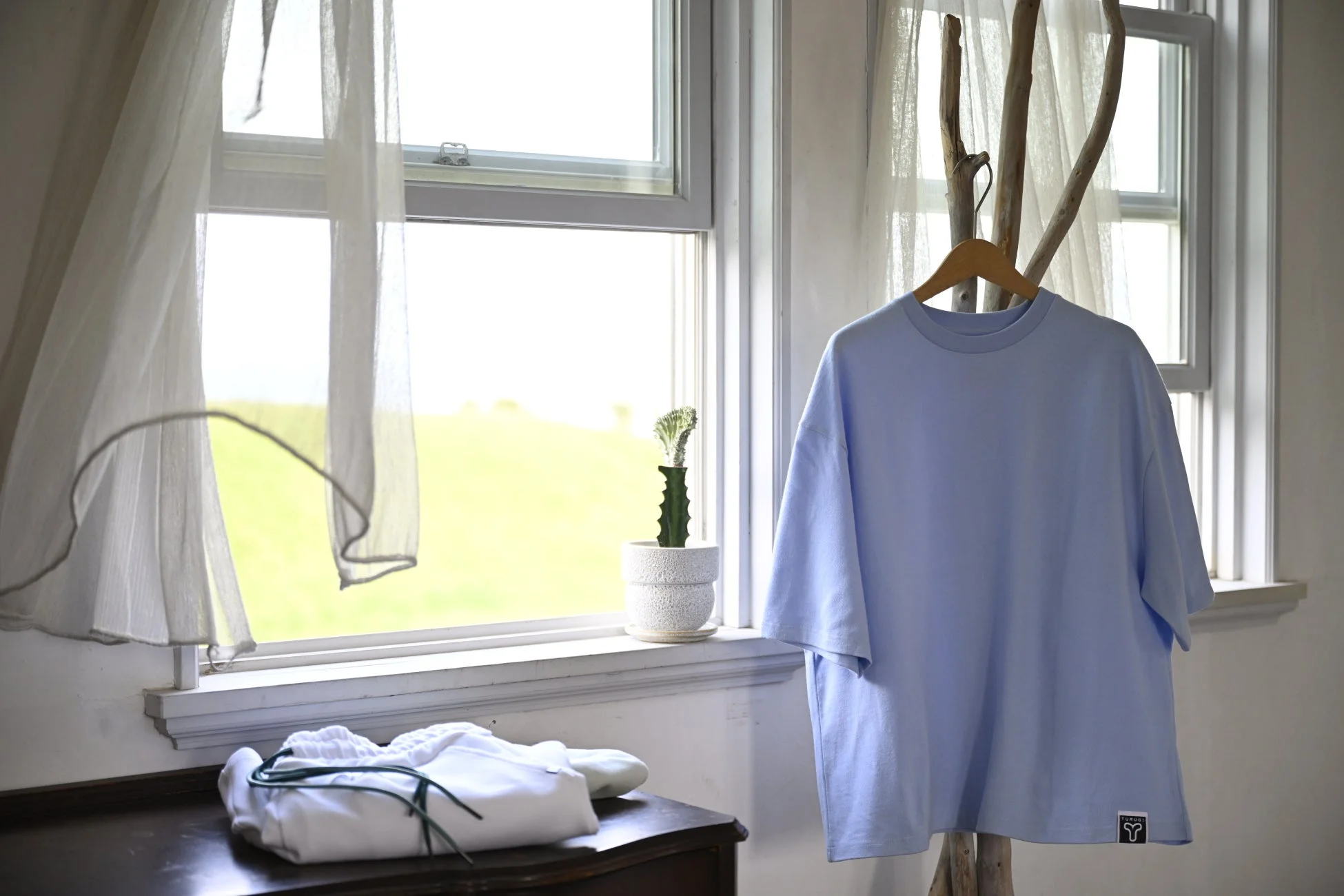 水色のTシャツが飾られた部屋