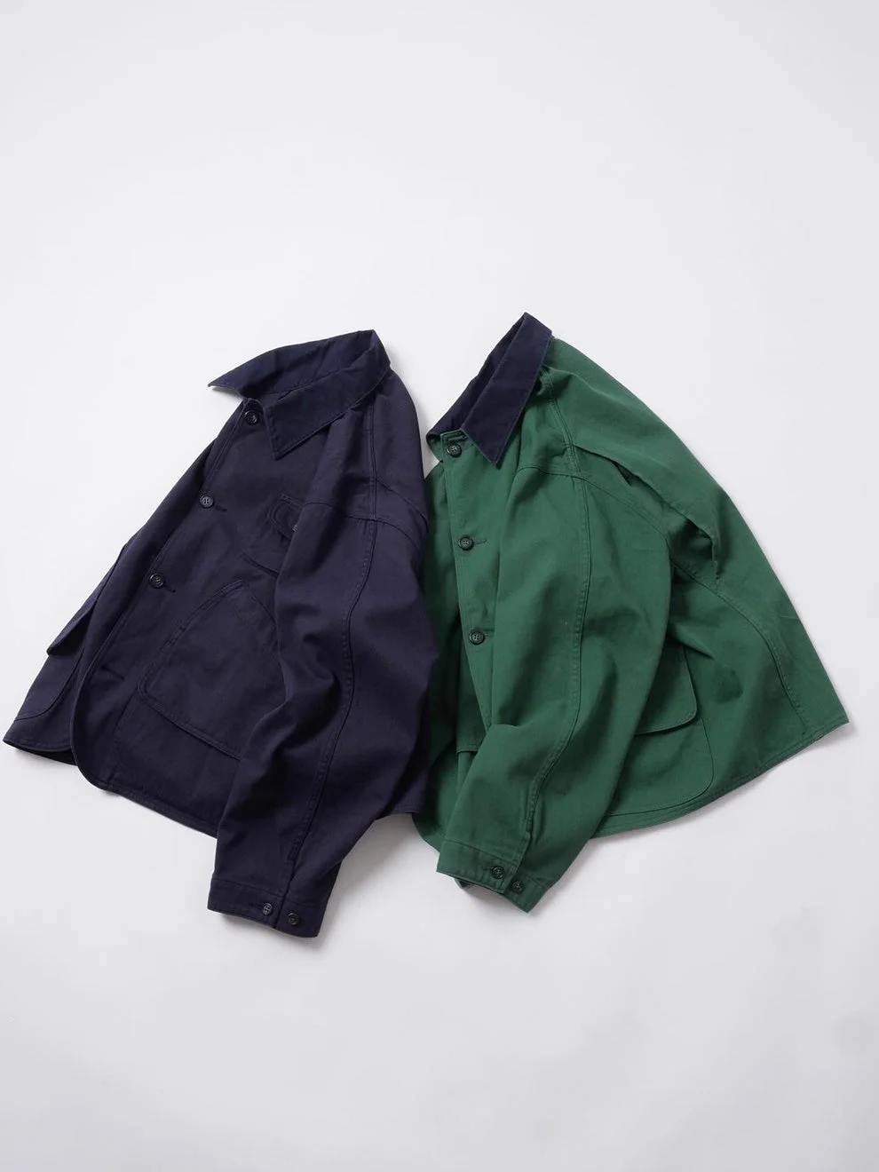平置きされたネイビーとグリーンのワークジャケット