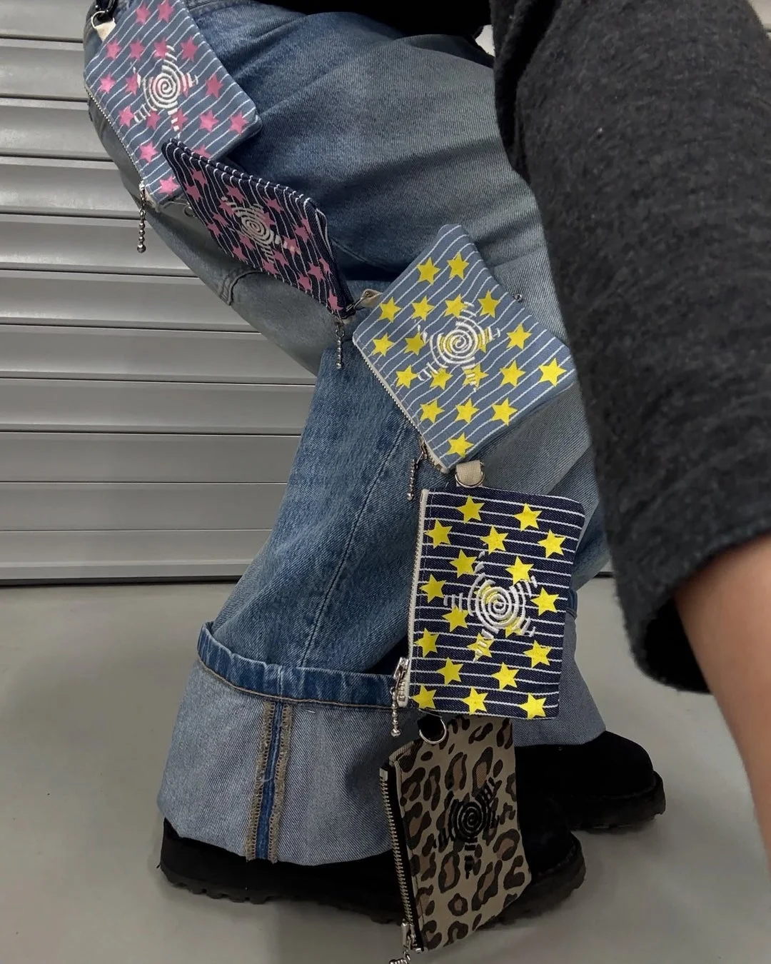 デニムジーンズに複数のポーチがぶら下がったファッションスナップ